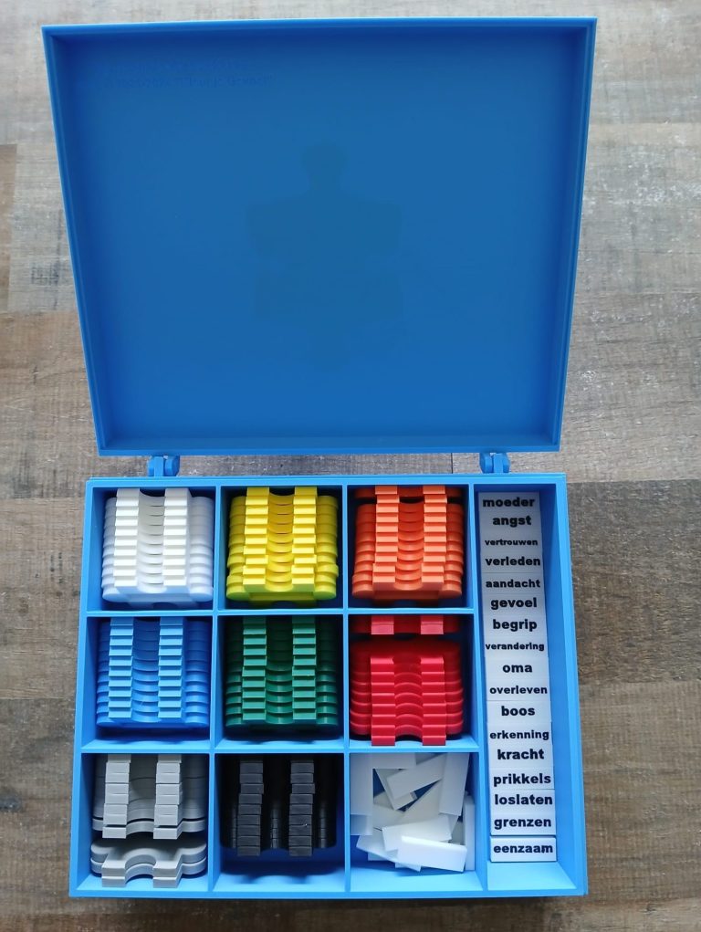 Puzzlebox Blauw Blauw doosje met opbergvakken voor verschillende kleurige puzelstukken en woordkaartjes.