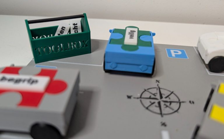 Puzzlebox Blauw Blauw doosje met opbergvakken voor verschillende kleurige puzelstukken en woordkaartjes.